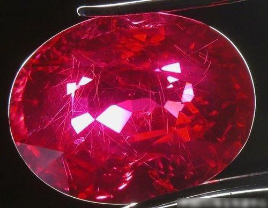 温札. 坦桑尼亚的红宝石，可见弯曲纤维状包体和多晶质次生矿物